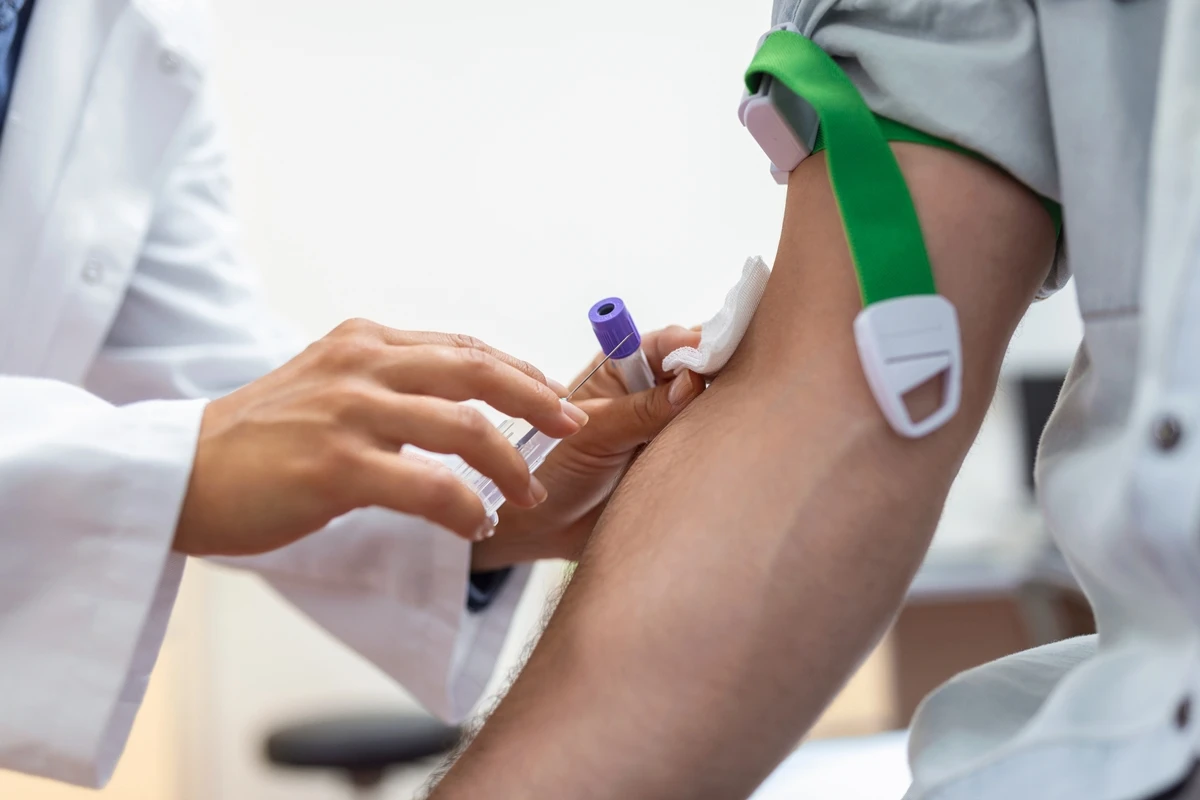 Preparação de exame de sangue por médica, uniforme médico, mesa, sala branca e iluminada; enf...