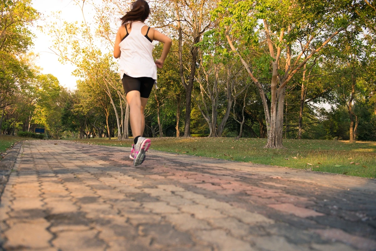 1 de 1 Jovem mulher correndo na mata, treinando e se exercitando para uma maratona de trilha ao n...