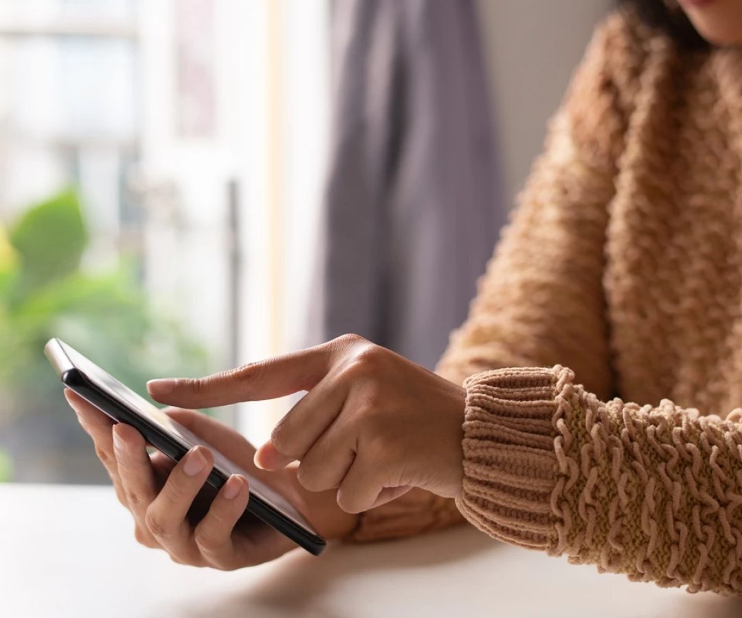 1 de 1 Imagem mostra uma mulher de casaco marrom mexendo no celular com um dedo - Metrópoles - F...
