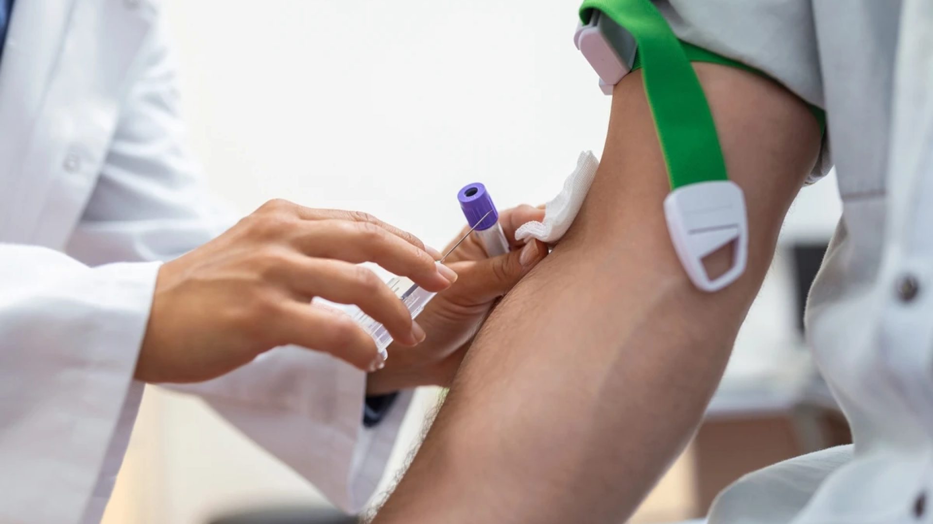 Preparação de exame de sangue por médica, uniforme médico, mesa, sala branca e iluminada; enf...