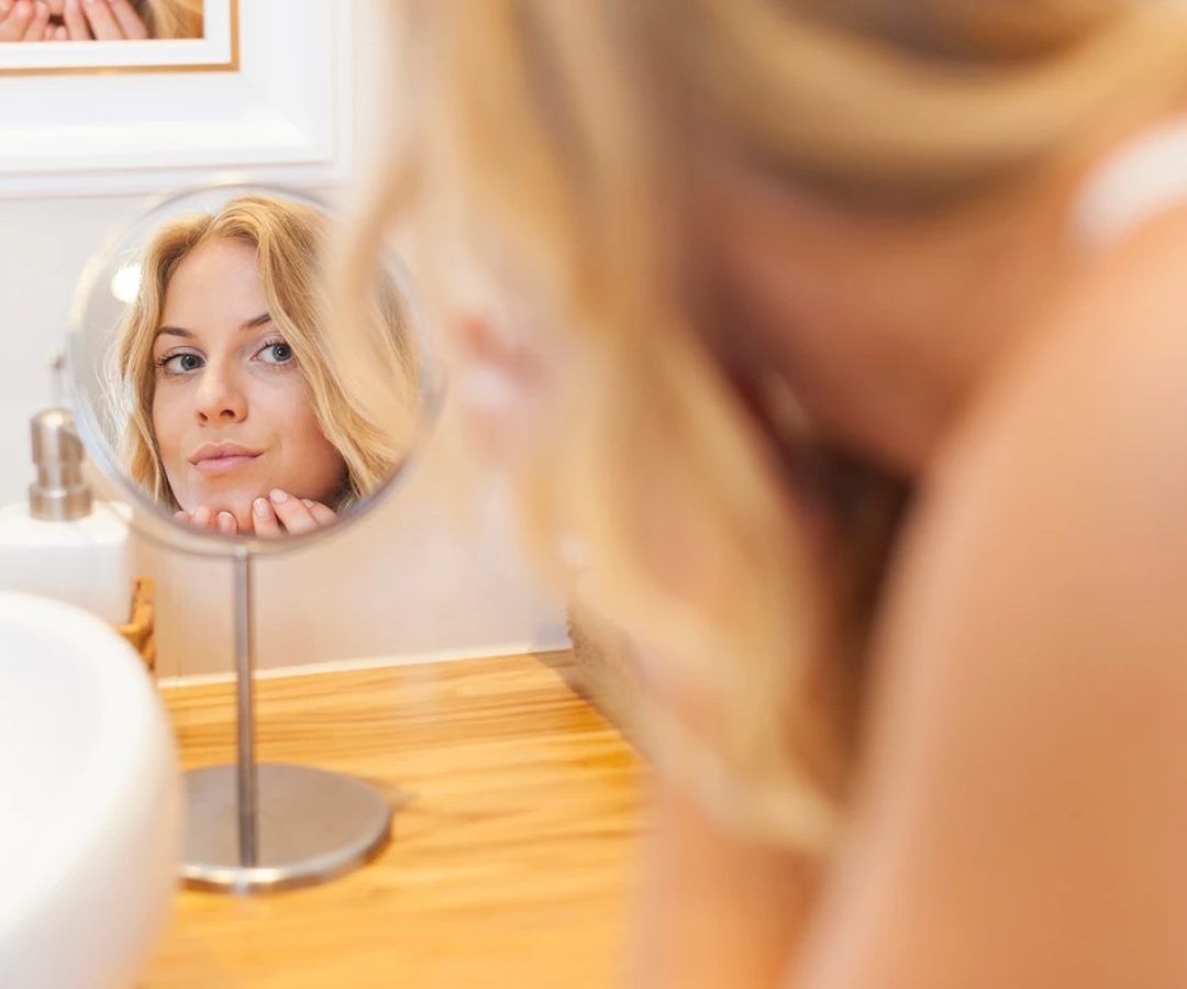 1 de 1 Mulher loira se olhando em espelho de banheiro- Metrópoles - Foto: Freepik