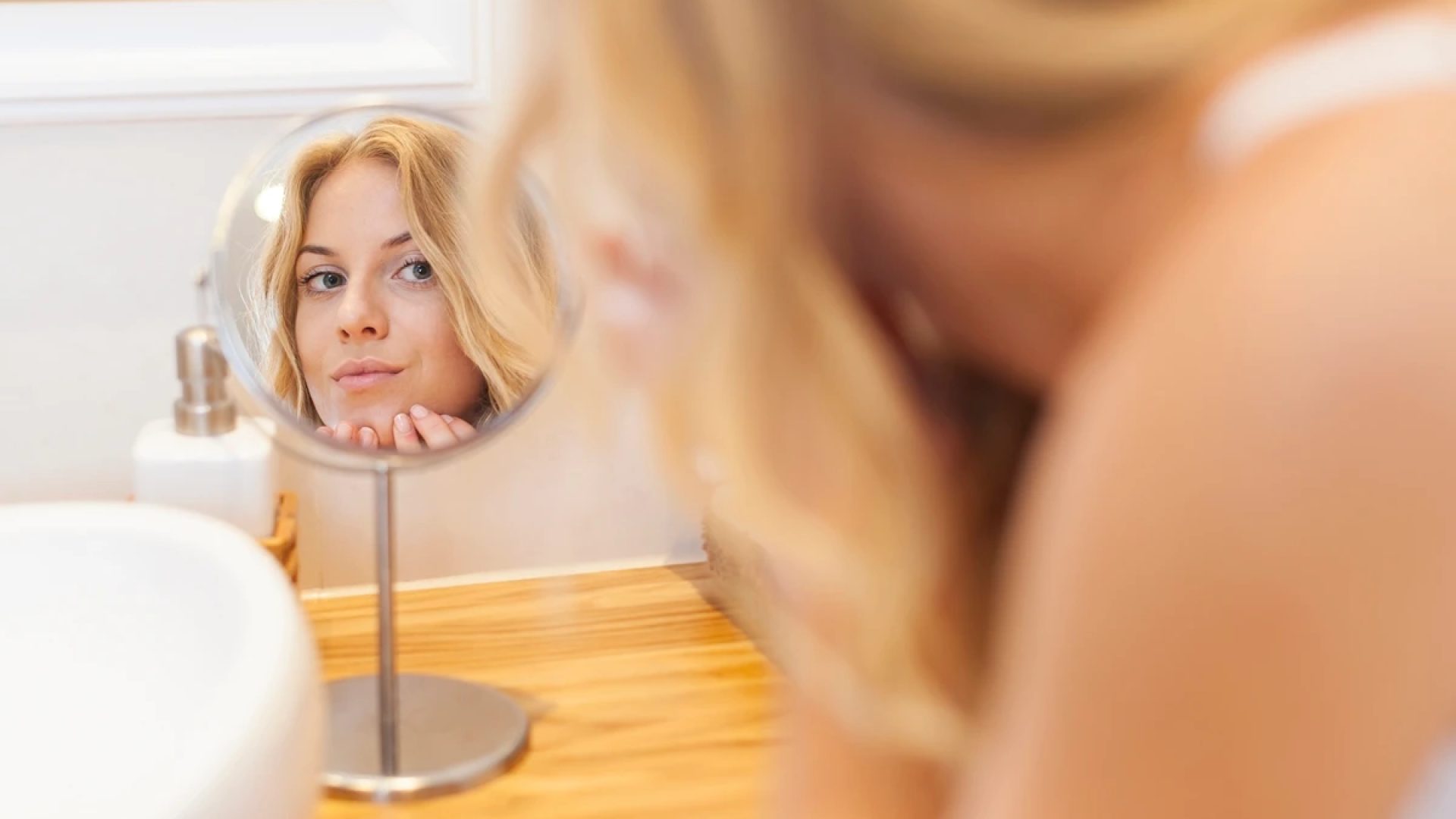 1 de 1 Mulher loira se olhando em espelho de banheiro- Metrópoles - Foto: Freepik